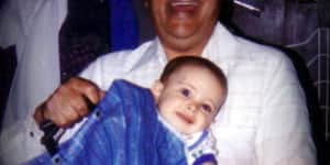 Jona's grandfather holds him.