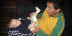 Jona holding a baby in his lap.