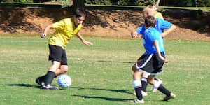 Jona dribbles the ball during a soccer game.